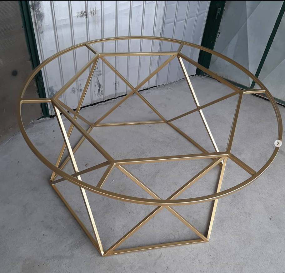 A modern sleek, glass table in gold color